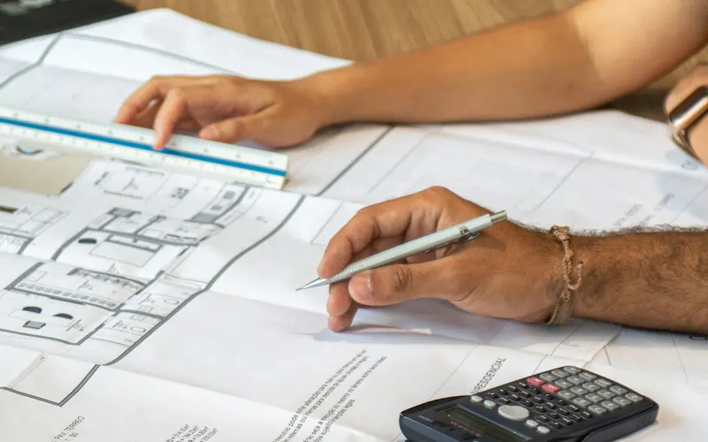 Reviewing a home's floor plans with a calculator